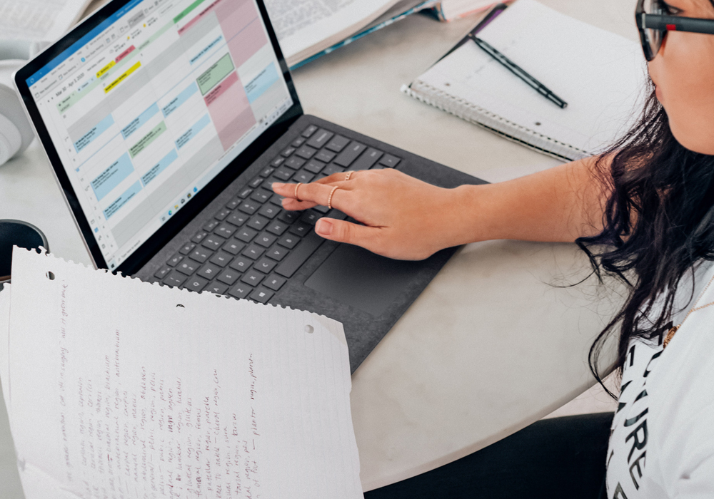 student in front of a computer with notes