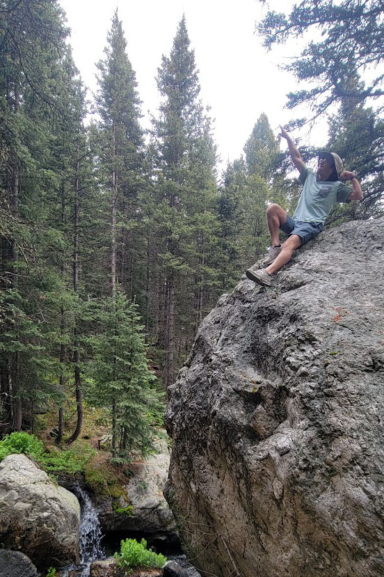 Courville sits on rock in nature area