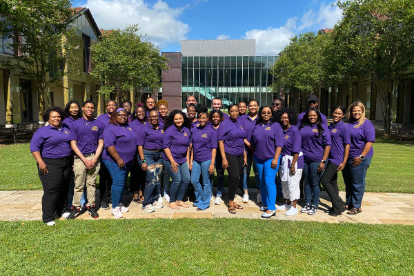 Bootcamp attendees in a group holding their completion certificates. 