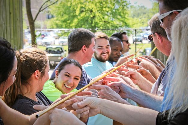 Group works together to hold up a pole