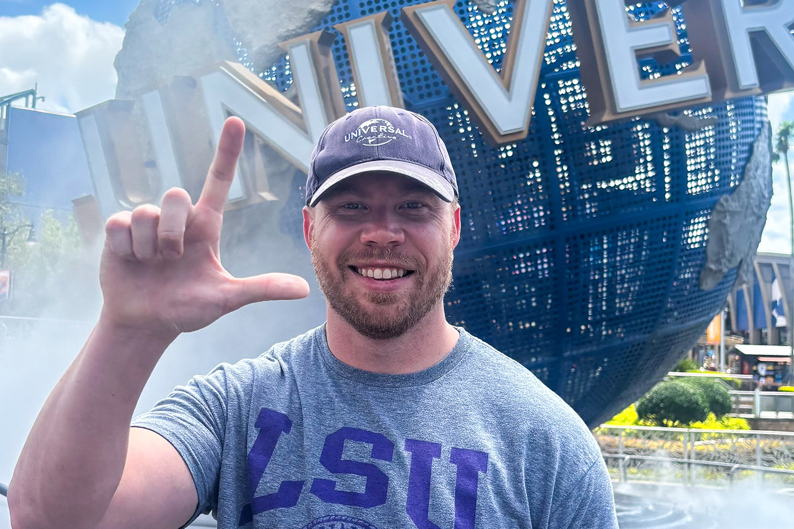 Donald Morrison holds an L hand in front of Universal Studios