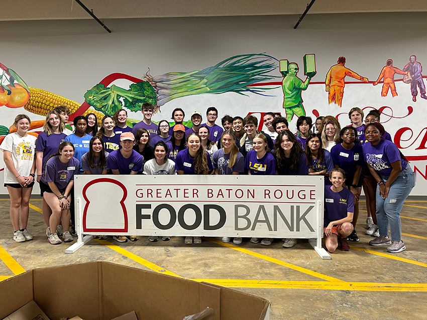 group of LSU students hold banner at Greater Baton Rouge Food Bank.