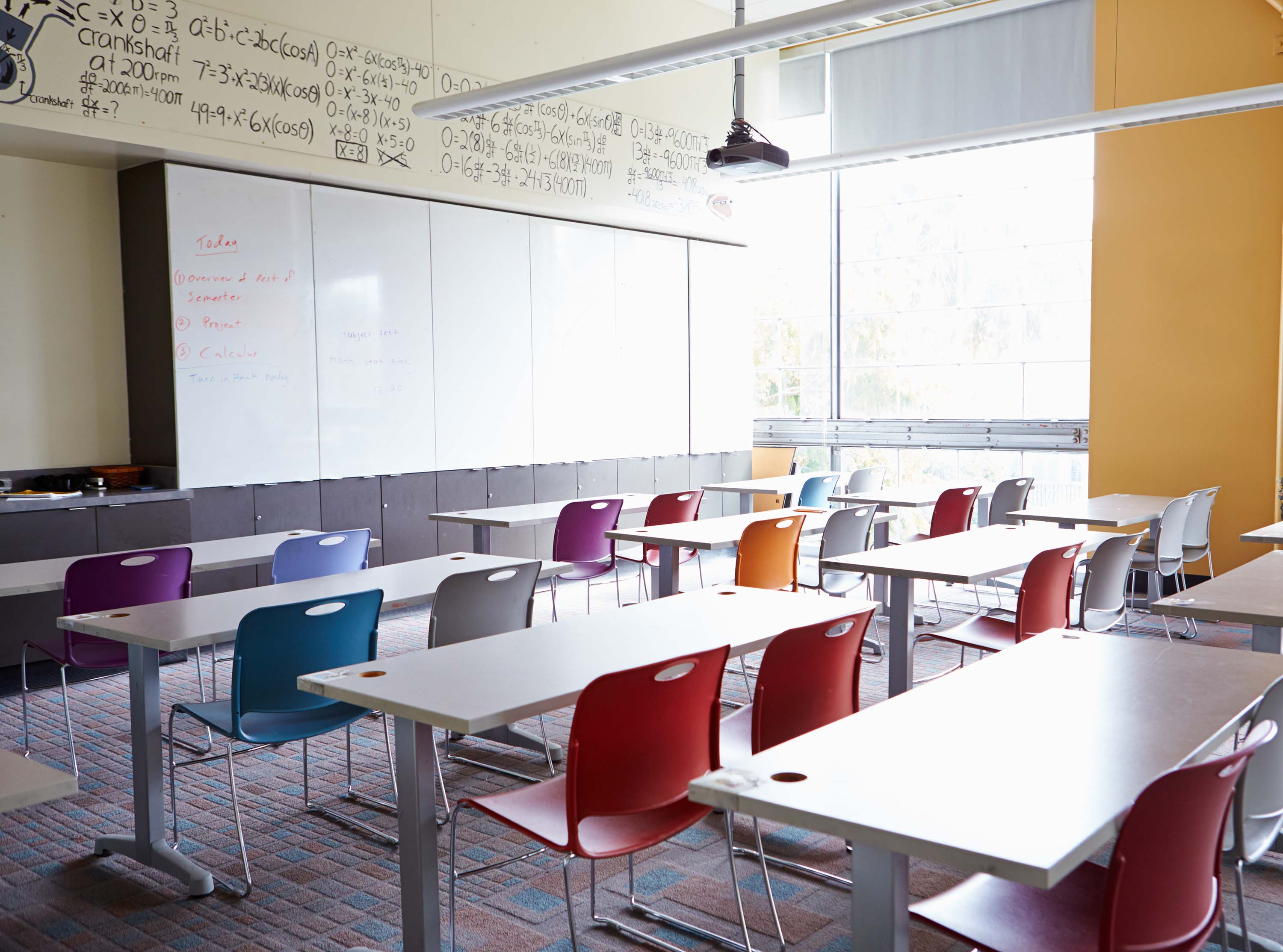 image of emty classroom with rows of desks and chairs