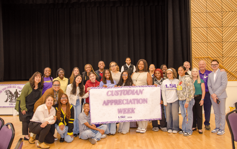 group standing with banner
