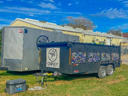 An Osprey trailer with bottles and cans in it. 